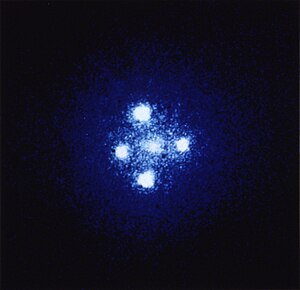 Einstein cross: Four images of the same distant quasar (due to the gravitational lensing of the galaxy closest to us, shown in the foreground, the Huchra Lens).